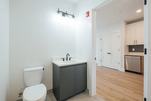 a bathroom with a toilet a sink and mirror