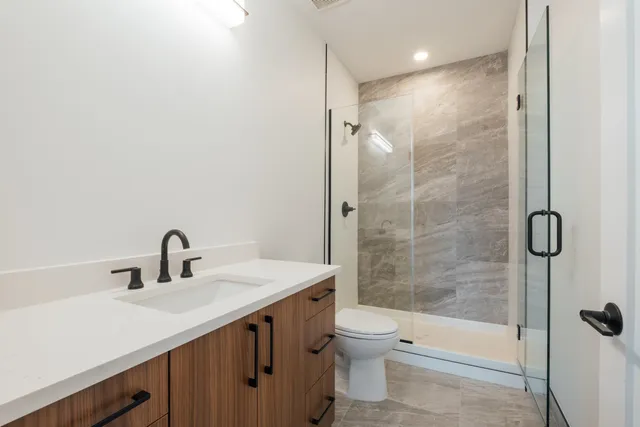 a bathroom with a sink a toilet and shower