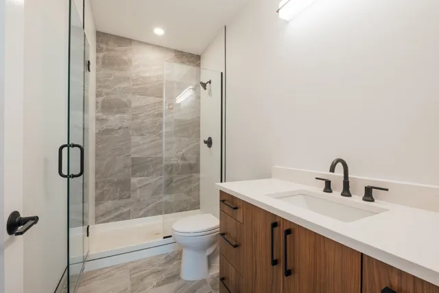 a bathroom with a sink mirror toilet and shower