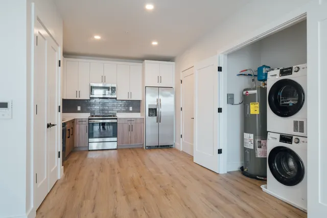 a kitchen with white cabinets and stainless steel appliances