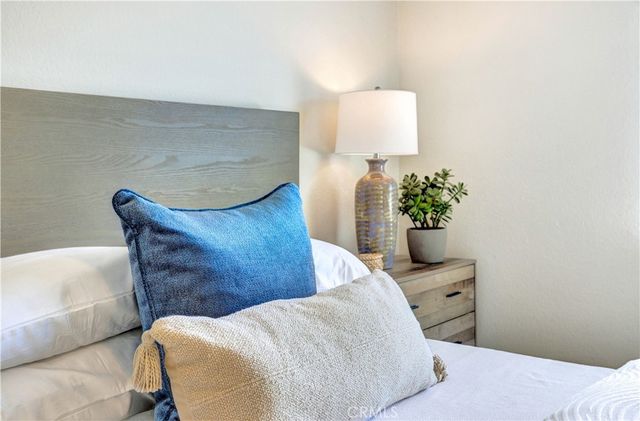 a bedroom with a bed and a potted plant