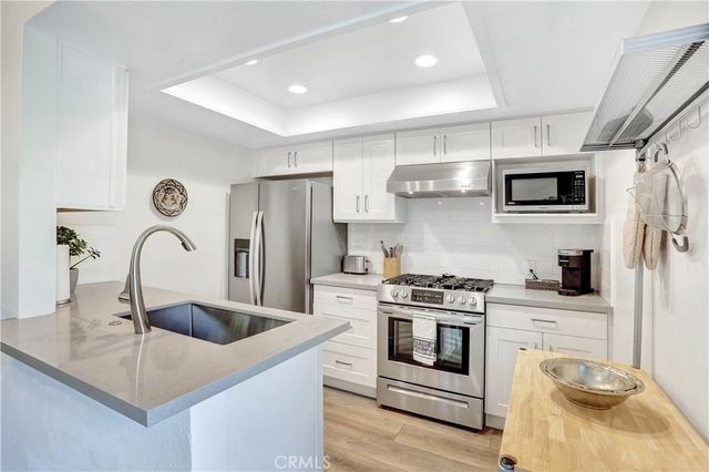 a kitchen with stainless steel appliances granite countertop a sink a stove a refrigerator and cabinets