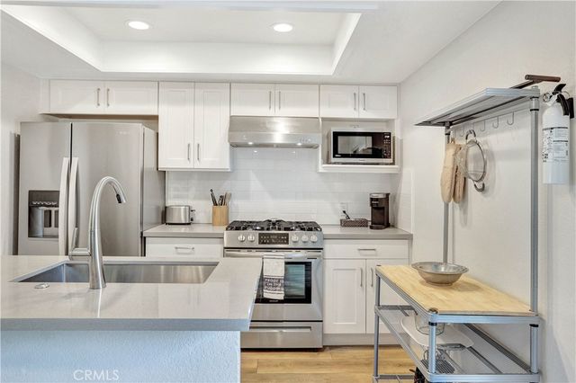 a kitchen with stainless steel appliances granite countertop a stove a refrigerator and a microwave