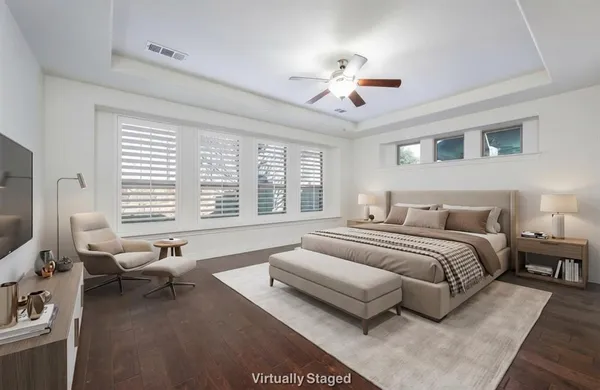 a spacious bedroom with a bed a couch and large windows