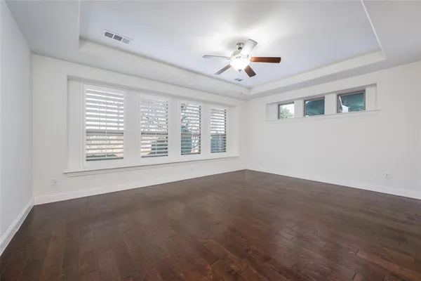 a view of an empty room with a window and chandelier fan