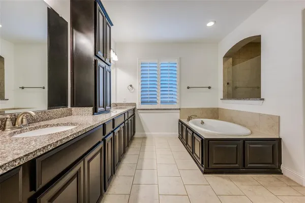 a bathroom with a granite countertop double vanity sink and a mirror