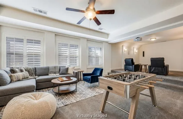 a living room with furniture a large window and a chandelier