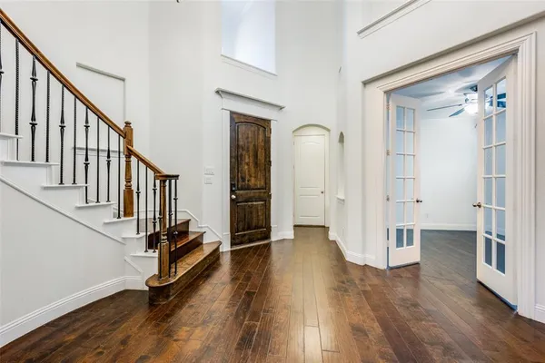 a view of a hallway with wooden floor and staircase