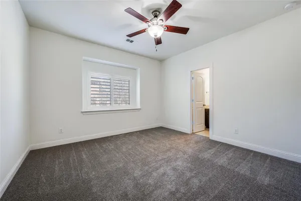 an empty room with a window and a ceiling fan