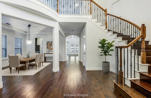 a view of a hallway with wooden floor table and windows