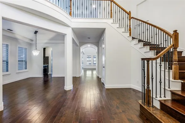 a view of a hallway with wooden floor and stairs