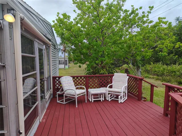 a balcony with wooden floor table and chairs