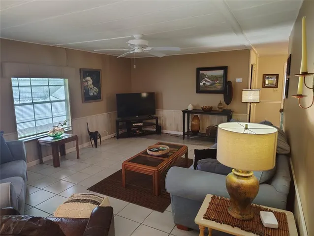 a living room with furniture a flat screen tv and a window