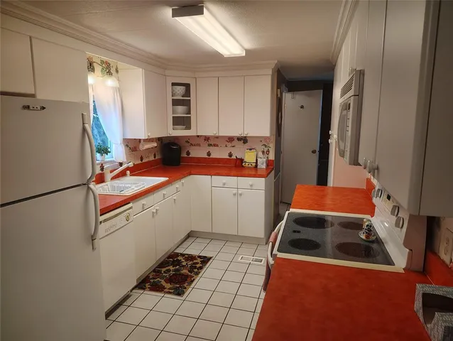 a kitchen with a refrigerator and a stove top oven