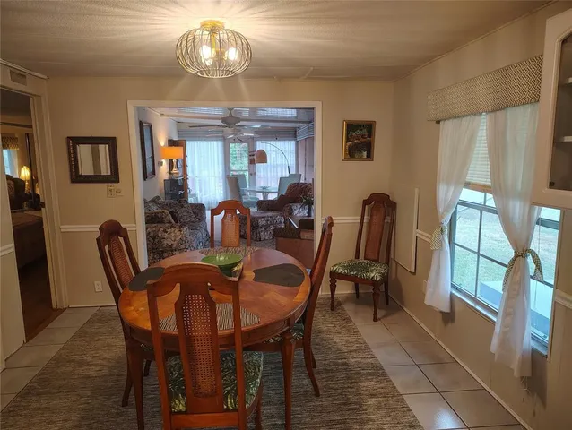 a dining room with furniture a chandelier and wooden floor