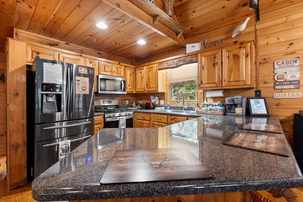35 Wunder Bear Ridge Morganton, GA 30560 - Photo 16 of 76 a kitchen with stainless steel appliances granite countertop a refrigerator a stove and a sink with wooden cabinets