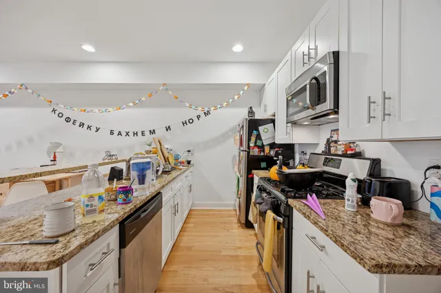 a kitchen with stainless steel appliances granite countertop a lot of cabinets