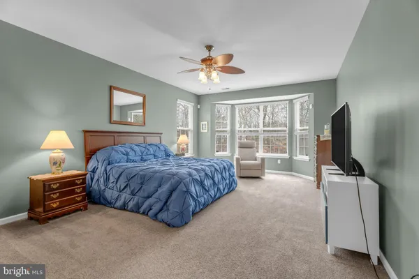 a bedroom with a bed and a flat tv screen on dresser