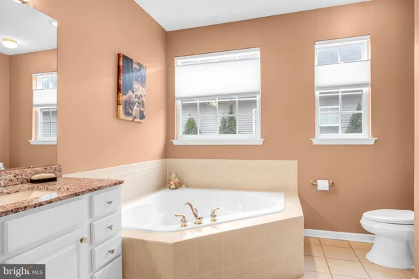 a bathroom with a granite countertop sink and a bathtub