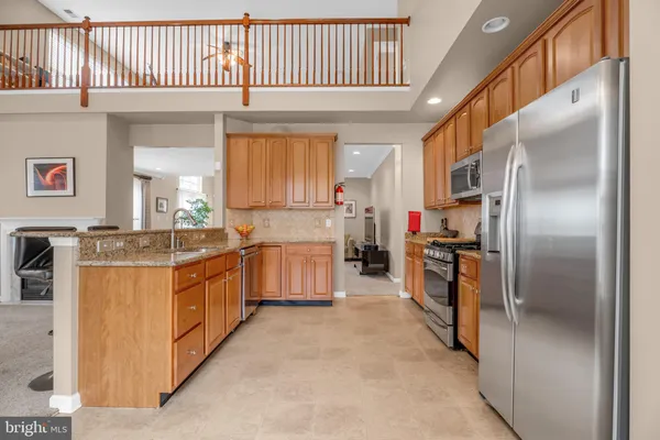 a kitchen with stainless steel appliances granite countertop a sink a stove and a refrigerator