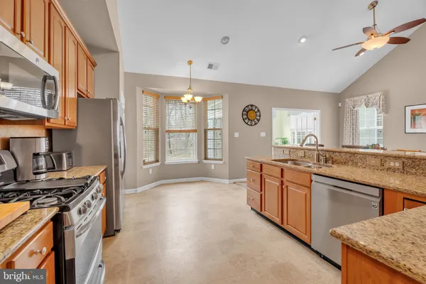 a kitchen with stainless steel appliances granite countertop a stove and a sink