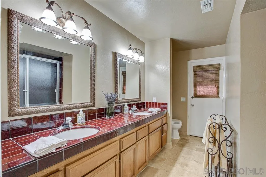 16508 Wilderness Road Poway, CA 92064 - Photo 13 of 25 a bathroom with a double vanity sink and a mirror