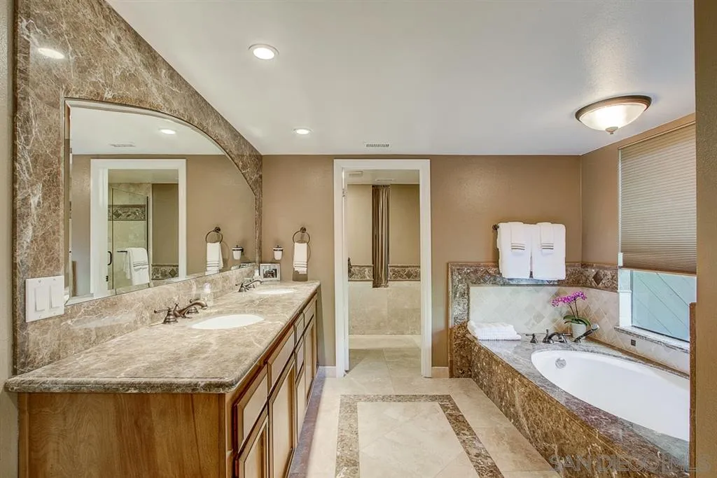 16508 Wilderness Road Poway, CA 92064 - Photo 18 of 25 a spacious bathroom with a granite countertop sink and a mirror