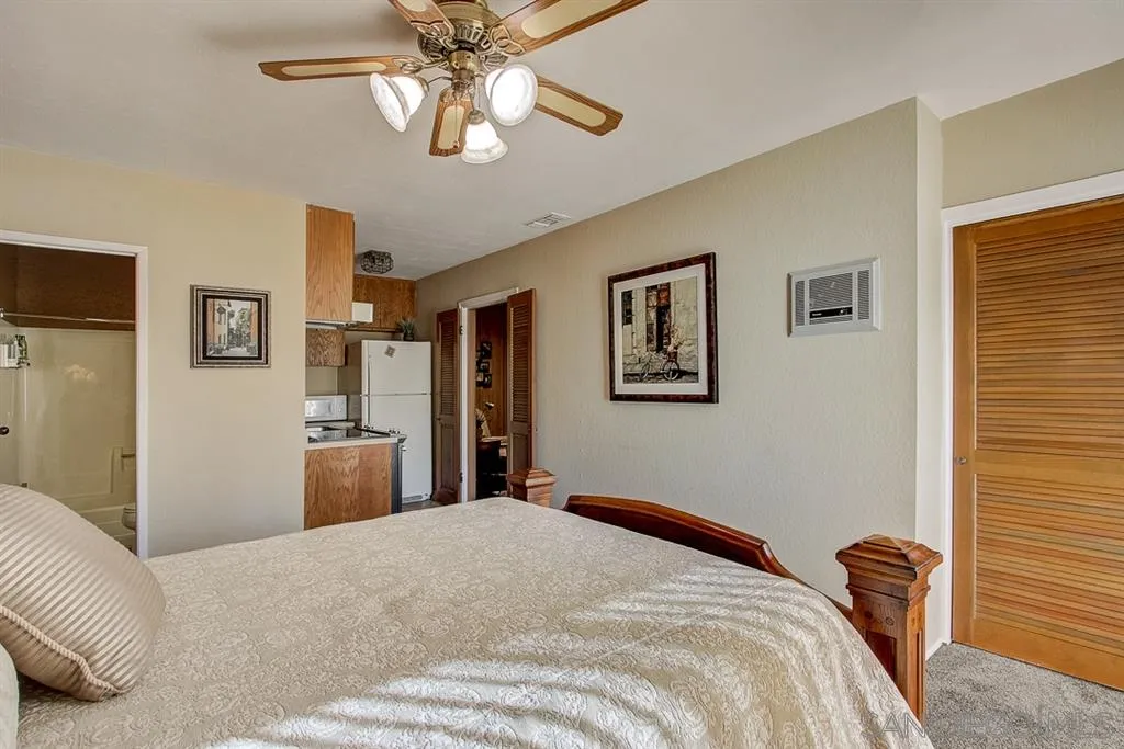 16508 Wilderness Road Poway, CA 92064 - Photo 9 of 25 a bedroom with a large bed and a chandelier