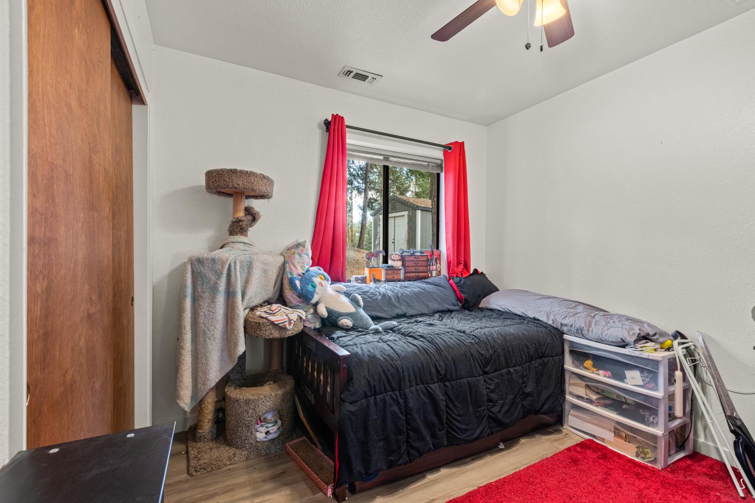 5680 Azalea Circle Pollock Pines, CA 95726 - Photo 15 of 31 a bedroom with a bed and a chandelier