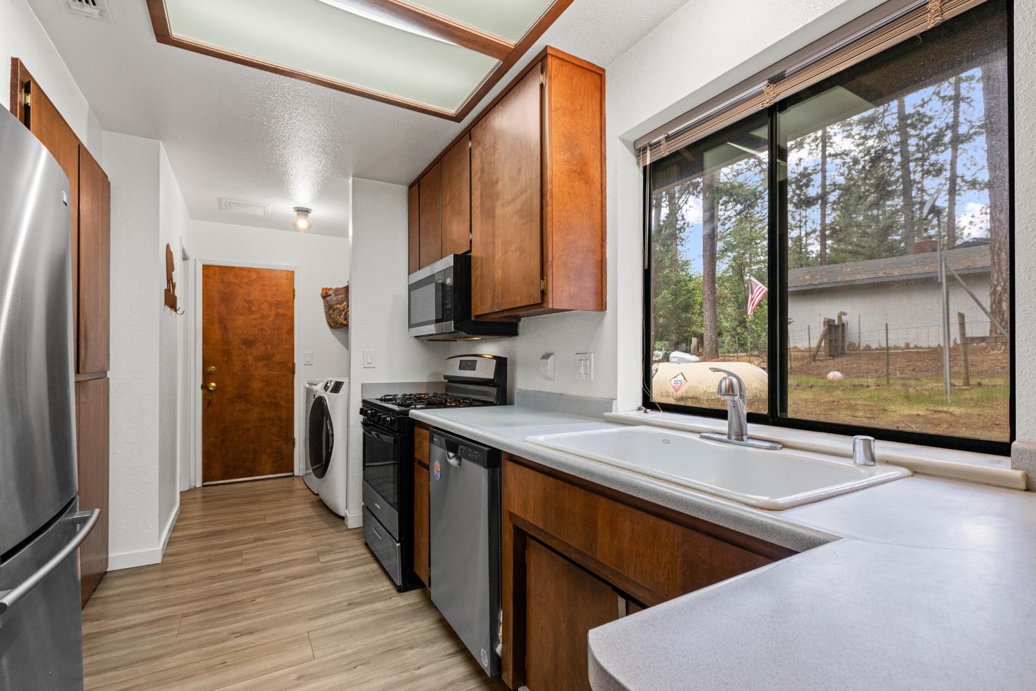 5680 Azalea Circle Pollock Pines, CA 95726 - Photo 7 of 31 a kitchen with stainless steel appliances granite countertop a sink a stove and a refrigerator