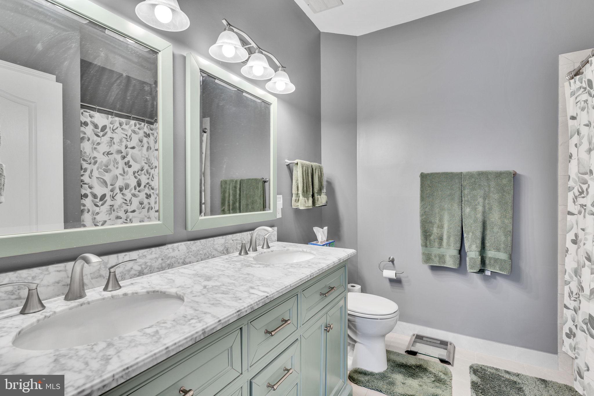 7706 Haynes Point Way, Unit 8F Alexandria, VA 22315 - Photo 19 of 36 a bathroom with a granite countertop sink a toilet and a mirror