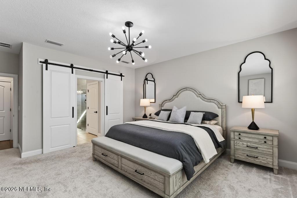 240 Ranch Land Circle St. Johns, FL 32259 - Photo 23 of 117 a bedroom with a bed and a chandelier