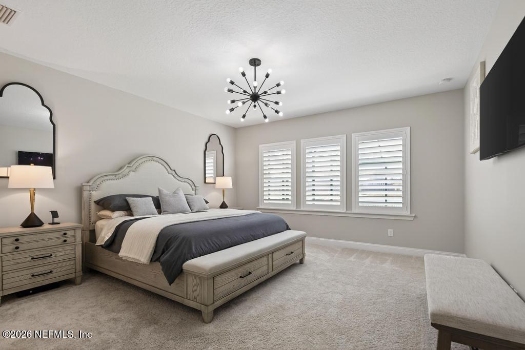 240 Ranch Land Circle St. Johns, FL 32259 - Photo 24 of 117 a spacious bedroom with a bed a television and a large window