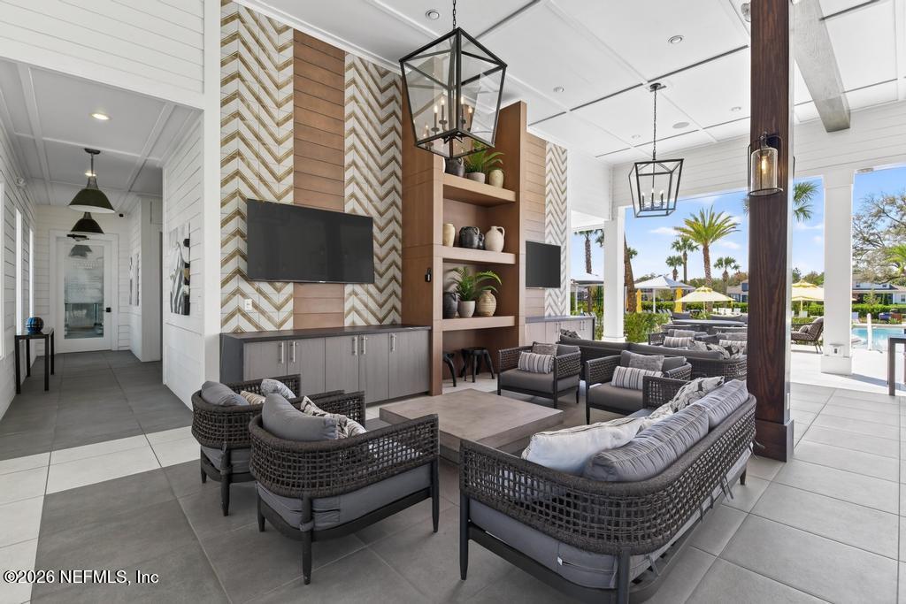 240 Ranch Land Circle St. Johns, FL 32259 - Photo 84 of 117 a living room with furniture a flat screen tv and a floor to ceiling window