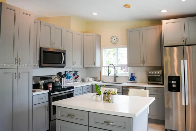 a kitchen with stainless steel appliances a refrigerator sink and white cabinets