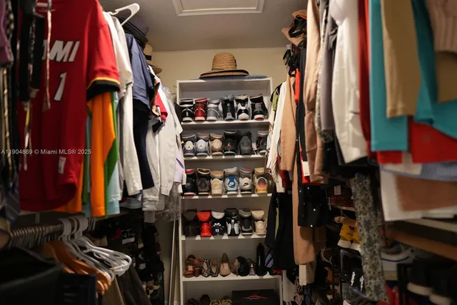 a view of walk in closet with clothes and shoes