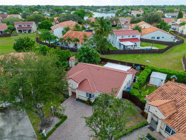 an aerial view of residential houses with outdoor space and a street view