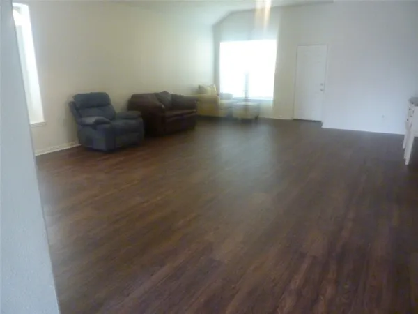 a living room with furniture and a hard wood floor