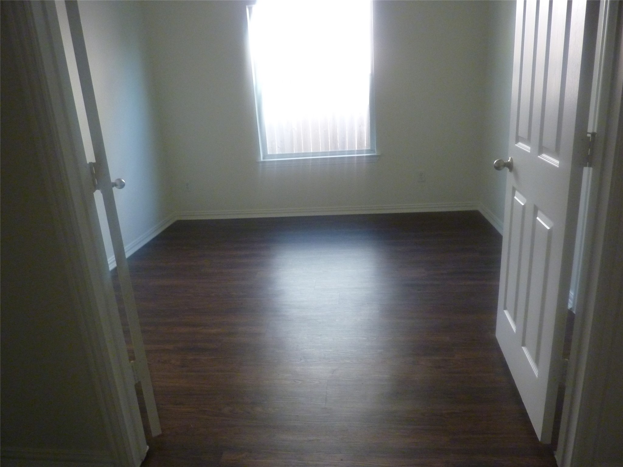 24038 Clipper Hill Lane Spring, TX 77373 - Photo 7 of 14 an empty room with wooden floor and windows with curtains