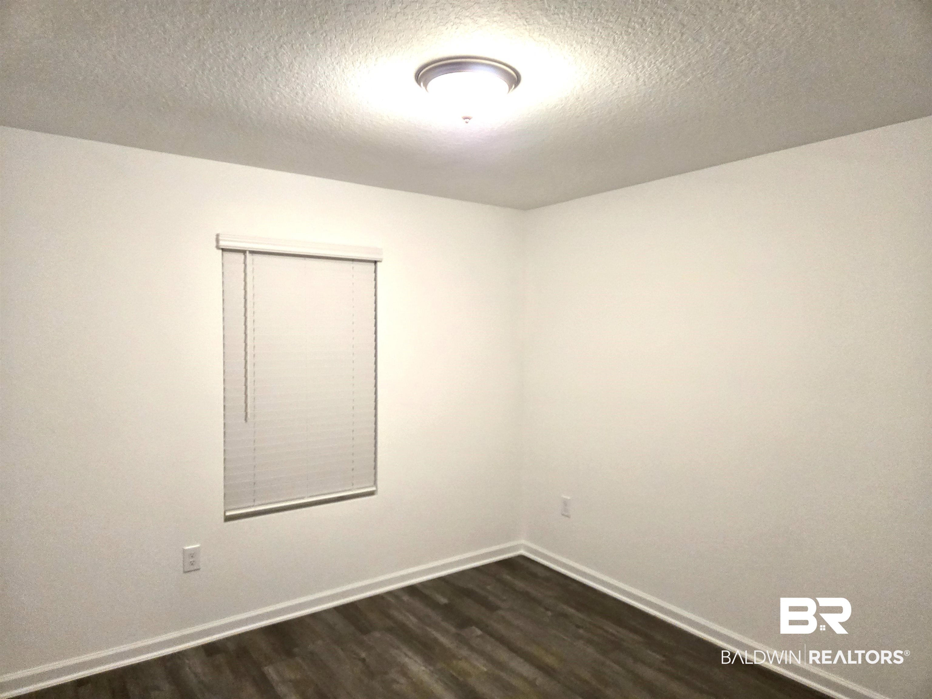 24321 Ringneck Loop Elberta, AL 36530 - Photo 18 of 39 Empty room featuring dark hardwood / wood-style floors and a textured ceiling