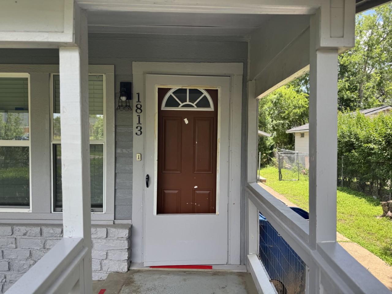 1813 Rhodes Road Austin, TX 78721 - Photo 2 of 14 A welcoming front porch features a charming entryway with an arched glass detail above the door.