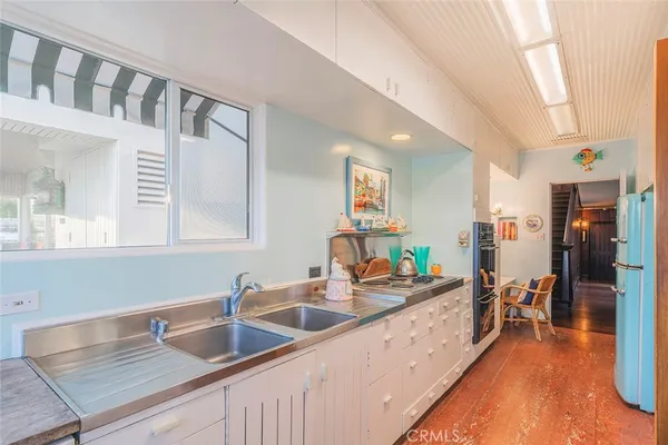 a kitchen with stainless steel appliances granite countertop a sink dishwasher and cabinets with wooden floor