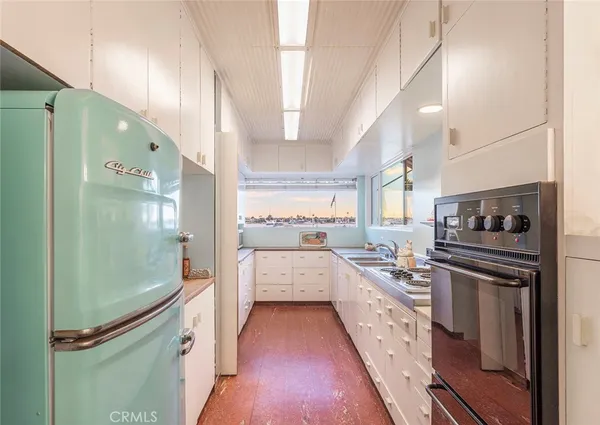 a kitchen with a refrigerator and white cabinets