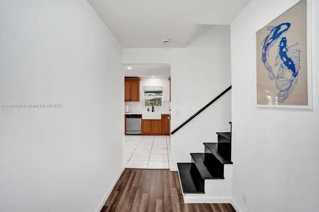 a view of a hallway with wooden floor and entryway