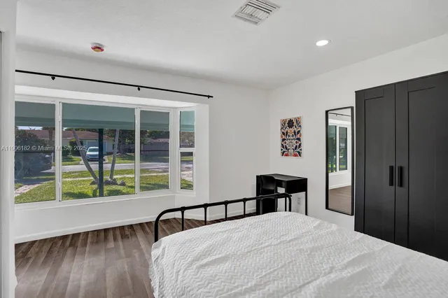 a bedroom with a bed and wooden floor