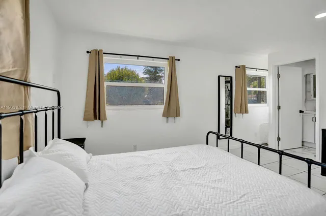 a view of a hallway with wooden floor and a bathroom