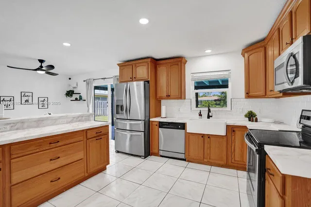 a kitchen with stainless steel appliances granite countertop a refrigerator and a stove top oven