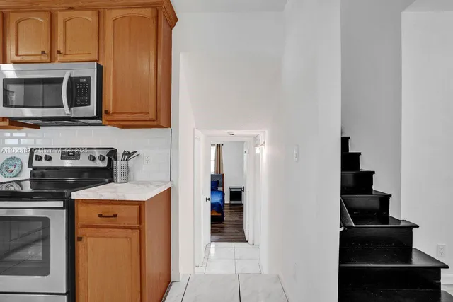 a kitchen with stainless steel appliances granite countertop a refrigerator stove top oven and sink