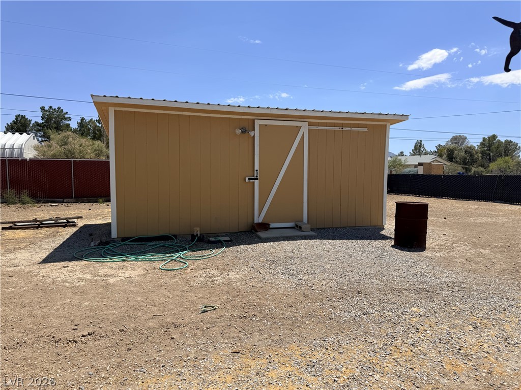 1391 West Dyer Road Pahrump, NV 89048 - Photo 24 of 50 A utilitarian shed provides practical outdoor storage within a gravel and dirt lot.