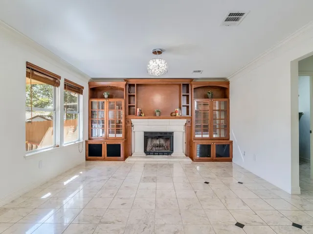 wooden floor fireplace and windows in an empty room